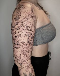 a woman's half sleeve with flowers and leaves on her arm, in black and white