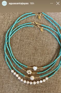 a blue beaded necklace with white stars and hearts on the beads is sitting on a table