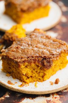 a piece of cake sitting on top of a white plate next to a wooden spoon