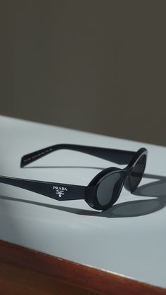 The new Prada Symbole sunglasses reinterpret the narrow oval shape with a contemporary flair. Fine faceted temples recreate the triangle shape featuring the Prada iconic logo. Prada Symbole Sunglasses, Sunglasses Women Designer, Mens Travel, Adidas Football, Stylish Glasses, The Triangle