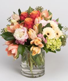 a vase filled with lots of different colored flowers