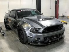 a silver car parked in a garage next to other cars