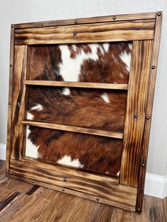 "SAVE when you order on our website 🌵🤎 https://farmsteadsignco.com This genuine cowhide shelf is the perfect western touch for any cowgirl, or cowboy. Perfect for belt buckles, or any other important items you want to display.  Entire display is 22.5\"x25.5\"  These are handcrafted on our farm in NE, Colorado with genuine cowhide and pine frame/shelves. Sizing/studs can be customized if requested. Just send us a message before placing your order. Production time is 4-5 weeks." Western Shelving Ideas, Belt Buckle Shelf, Western Shelf, Western Projects, Ag Mechanics, Belt Buckle Display, Frame Shelves, Buckle Display, Bullet Crafts