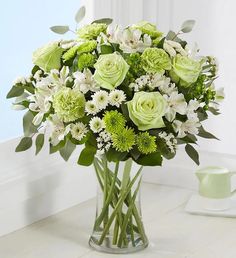 a vase filled with white and green flowers