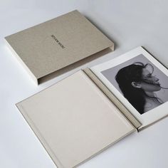 an open book with a black and white photo on the cover is next to it