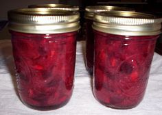 two jars filled with red liquid sitting on top of a table