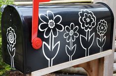 a black mailbox with flowers painted on it