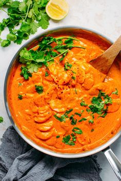 a pan filled with red sauce and garnished with cilantro