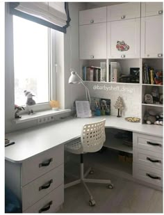 a white desk sitting next to a window in a room with lots of books on it