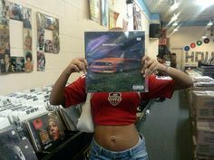 a woman holding up a cd in front of her face with the album on it's cover