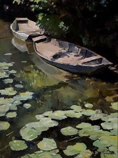 two boats floating on top of a lake filled with water lillies and lily pads