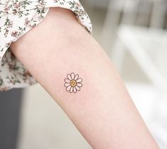 a small flower tattoo on the arm