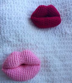 two crocheted lips laying next to each other on top of a white blanket