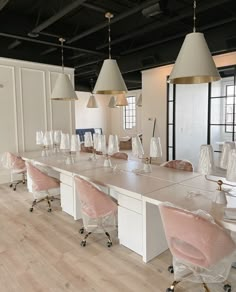 a long table with chairs and lamps on it