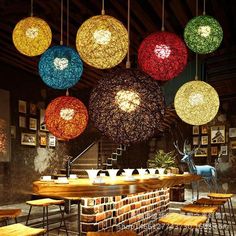 the lights are hanging from the ceiling above the bar in the restaurant with wooden chairs and stools