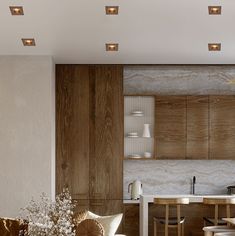 a living room filled with furniture next to a dining table and kitchen counter top area