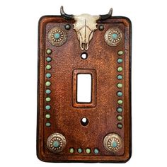 a light switch cover with a cow's skull and turquoise beads on the front