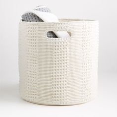 a white basket with a towel in it