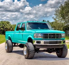 a bright blue truck is parked on the road