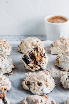 cookies are on a baking sheet next to a cup of coffee