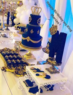 a table topped with lots of blue and gold cakes