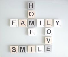 scrabble tiles spelling the words family, love, and smile on a white background