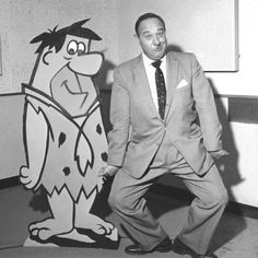 a man in a suit standing next to a cartoon character