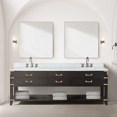 two mirrors are above the double sink vanity in this white and black bathroom with gold trim