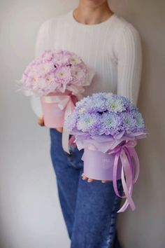 two women holding bouquets of flowers in their hands, both wearing white sweaters