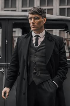 a man in a suit and tie standing next to a car