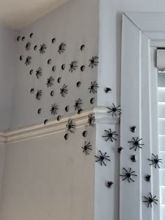 several black and white spider magnets are on the wall next to an open door