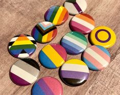 several different colored buttons sitting on top of a wooden table