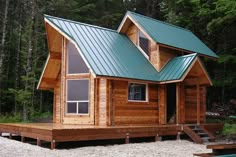 a small wooden cabin with a green roof