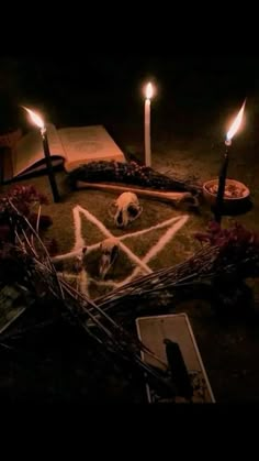 candles are arranged in the shape of a pentagram surrounded by books and other items