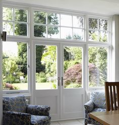 a living room filled with furniture and large windows