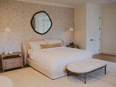 a large white bed sitting in a bedroom next to a dresser