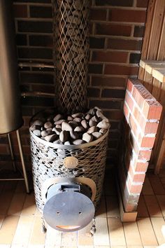 a fire place sitting next to a pile of rocks in a room with tile flooring