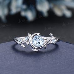 an oval blue topazte ring with leaves on it