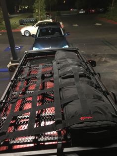 the back end of a truck with luggage on it's flatbed in a parking lot