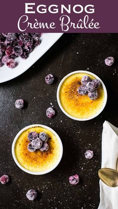 two white bowls filled with dessert on top of a black table next to silver spoons