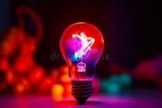 Light bulb with colorful light in the middle of the bulb and black background. Generative AI stock image Light Colors, Light Bulb, Color