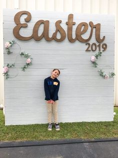 a girl standing in front of a sign that says easter