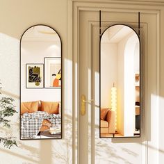 an arched mirror hangs on the wall next to a couch