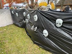 there are many fake skulls on the black tarp in front of this house that is covered with plastic