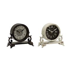 two clocks sitting next to each other on top of a white surface with black accents