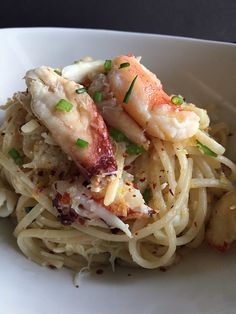 pasta with shrimp and scallops in a white bowl