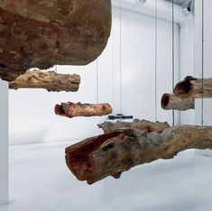 several pieces of wood hanging from the ceiling in a room with white walls and flooring