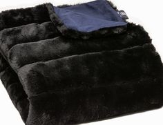 the black blanket is folded up on top of each other with a blue sheet underneath it