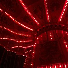 an illuminated carnival ride at night with red lights