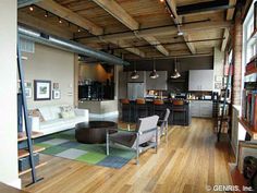 a living room filled with furniture next to a kitchen and dining room table in front of an open floor plan